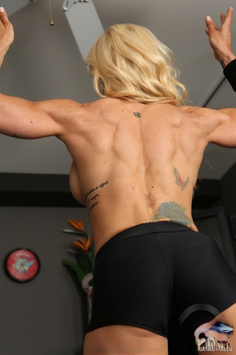 Busty bodybuilder Jill Rudison flexes naked while working out