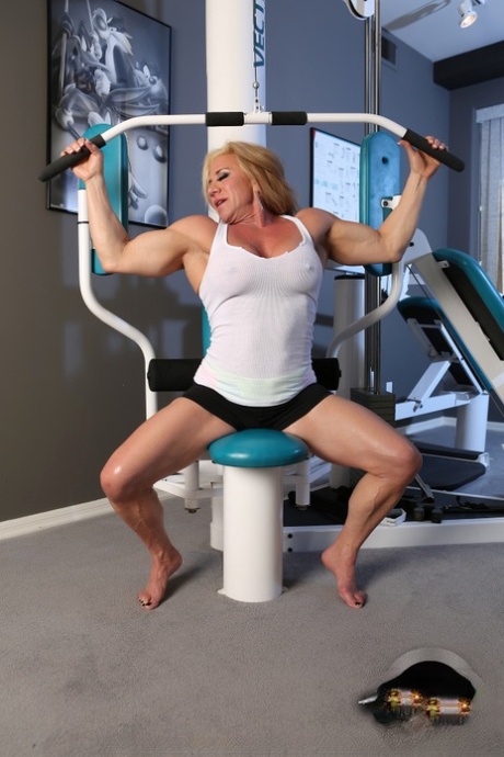 Hot mature bodybuilder Wanda Moore flexes her muscles in naked gym workout