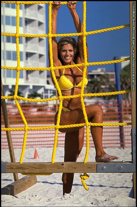 Blonde fitness model Torrie Wilson poses in bikinis while at the beach