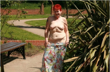 Older redhead Valgasmic Exposed gets totally naked in a public park