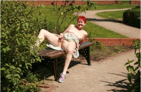 Older redhead Valgasmic Exposed gets totally naked in a public park