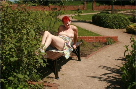 Older redhead Valgasmic Exposed gets totally naked in a public park