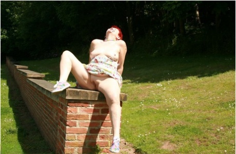 Older redhead Valgasmic Exposed gets totally naked in a public park