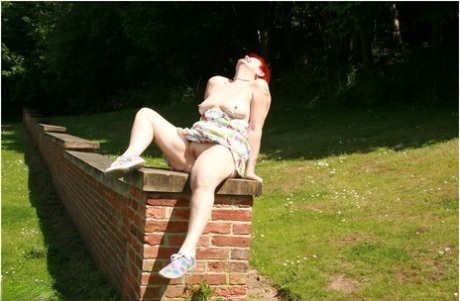 Older redhead Valgasmic Exposed gets totally naked in a public park