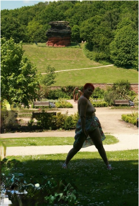 Older redhead Valgasmic Exposed gets totally naked in a public park