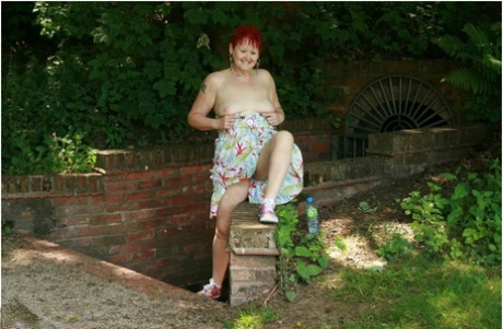 Older redhead Valgasmic Exposed gets totally naked in a public park