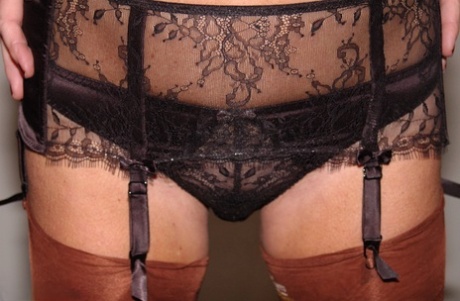 Older amateur removes a mask while wearing sheer lingerie and tan nylons