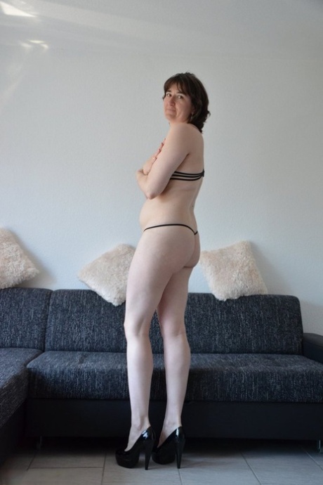 Pale older woman takes off her bra before slipping thong over her bare ass