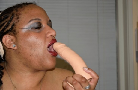 Obese ebony amateur Curvy Bunny B plays with a dildo while naked on a table