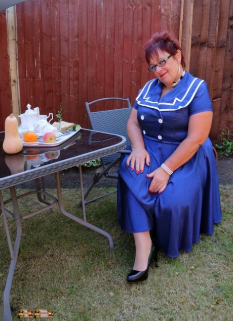 Mature fatty Warm Sweet Honey dangles a heel during upskirt action in a yard