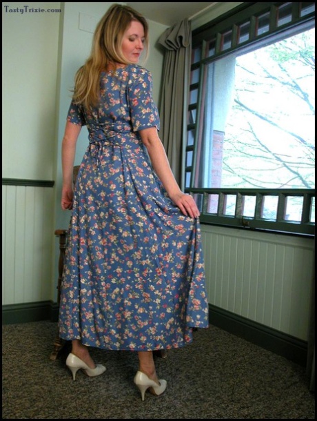 Mature lady Tasty Trixie hitches up her long dress before removing pink undies