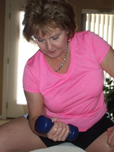 Older woman Busty Bliss exposes her nice tits while pumping iron at home