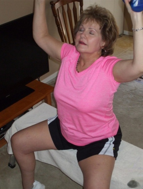 Older woman Busty Bliss exposes her nice tits while pumping iron at home