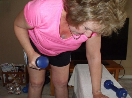 Older woman Busty Bliss exposes her nice tits while pumping iron at home