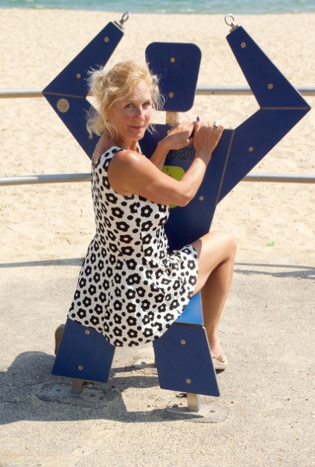 Mature blonde woman Molly exposes her tits and pussy at the beach