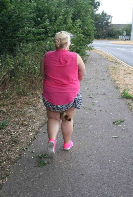 Fat UKwoman Lexie Cummings walks a path sporting a raccoon tail butt plug