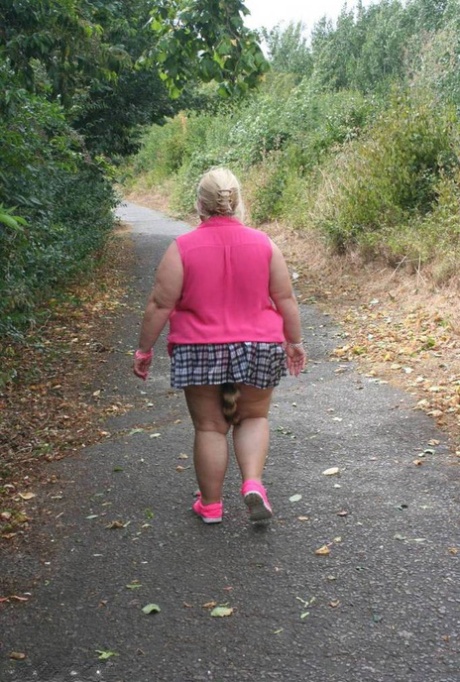 Fat UKwoman Lexie Cummings walks a path sporting a raccoon tail butt plug
