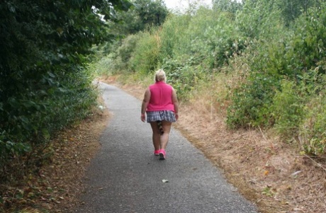 Fat UKwoman Lexie Cummings walks a path sporting a raccoon tail butt plug