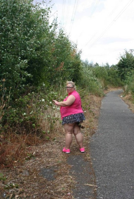 Fat UKwoman Lexie Cummings walks a path sporting a raccoon tail butt plug