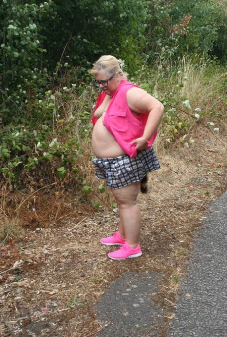 Fat UKwoman Lexie Cummings walks a path sporting a raccoon tail butt plug