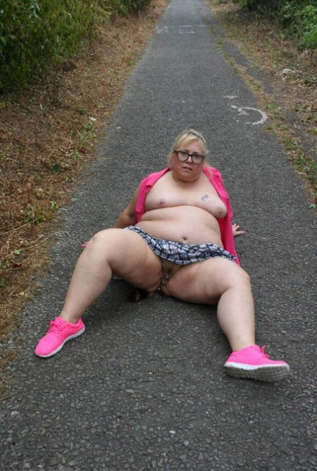 Fat UKwoman Lexie Cummings walks a path sporting a raccoon tail butt plug