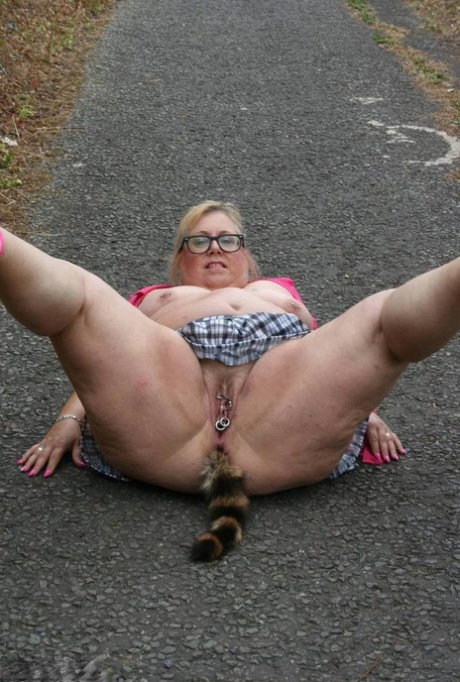 Fat UKwoman Lexie Cummings walks a path sporting a raccoon tail butt plug