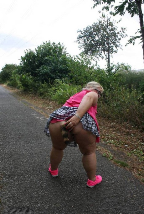 Fat UKwoman Lexie Cummings walks a path sporting a raccoon tail butt plug