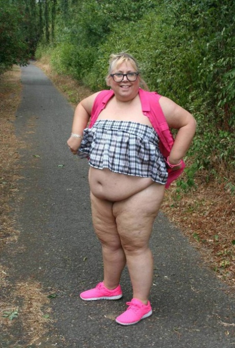 Fat UKwoman Lexie Cummings walks a path sporting a raccoon tail butt plug