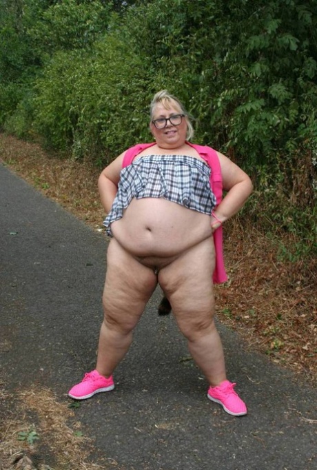 Fat UKwoman Lexie Cummings walks a path sporting a raccoon tail butt plug