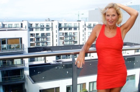 Mature blonde Molly MILF sets her large boobs free of red dress in solo action