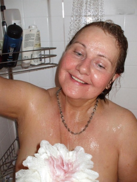 Naked older woman Busty Bliss washes her big boobs while taking a shower