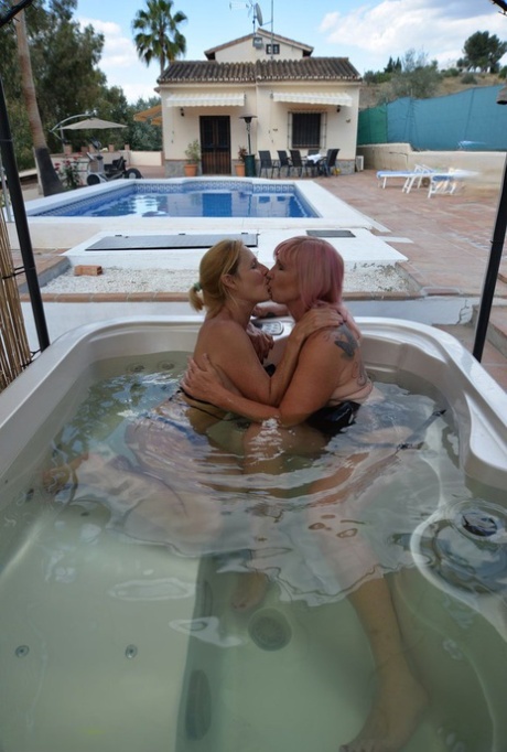 Mature lesbians with big tits kiss in a hot tub before licking pussy
