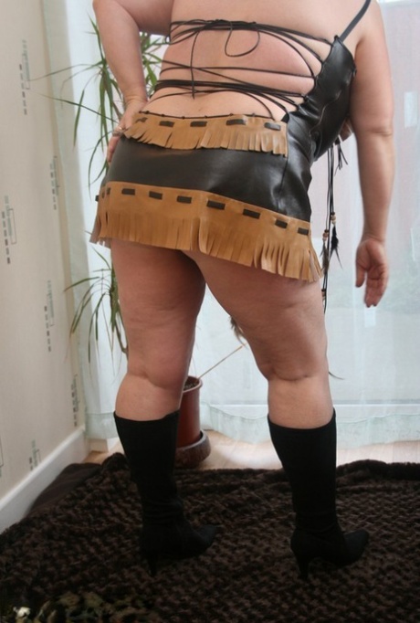 Sick mature woman Kinky Carol models leather lingerie in black boots