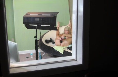 Blonde girl inserts a couple of huge dildos at the same time during a cam show