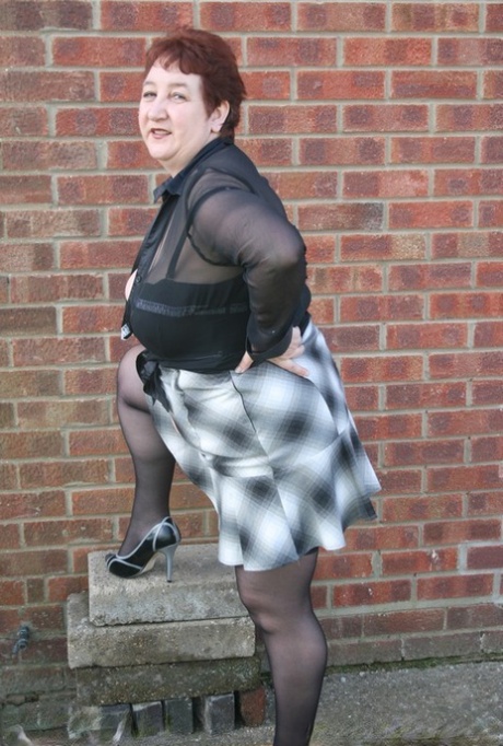 Mature redhead BBW Kinky Carol exposes her thong during outdoor upskirt action