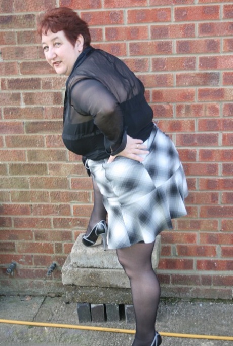 Mature redhead BBW Kinky Carol exposes her thong during outdoor upskirt action