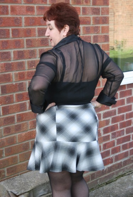 Mature redhead BBW Kinky Carol exposes her thong during outdoor upskirt action