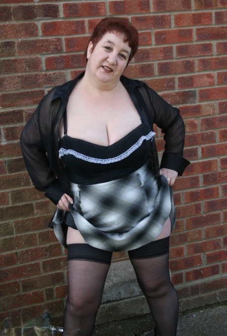 Mature redhead BBW Kinky Carol exposes her thong during outdoor upskirt action