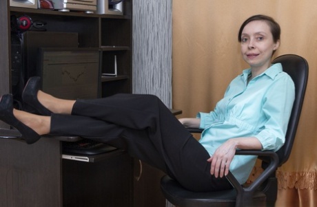 Older secretary Trixie sports short hair while modeling naked on a desk chair