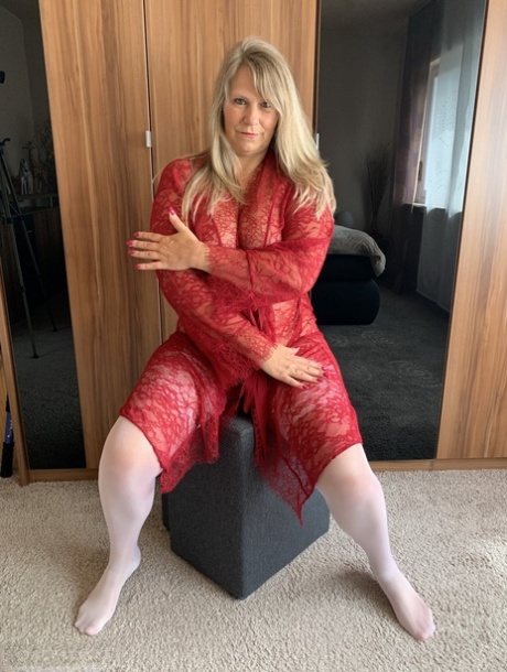 Mature blonde amateur Sweet Susi doffs a robe to pose nude in white stockings