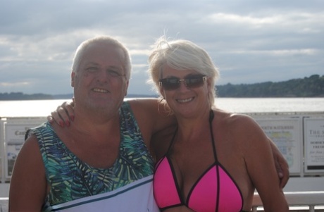 Mature blonde Dimonty eats a frozen treat after posing nude on a beach