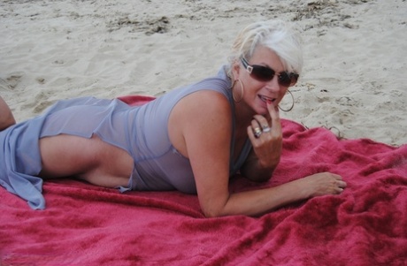 Mature platinum blonde Dimonty models at the beach in see through clothing