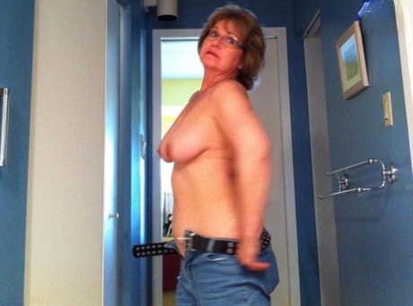 Older amateur Busty Bliss uncovers her natural tits while stripping naked