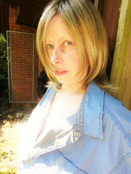 Older amateur Posh Sophia shows her large tits in a graffiti strewn building