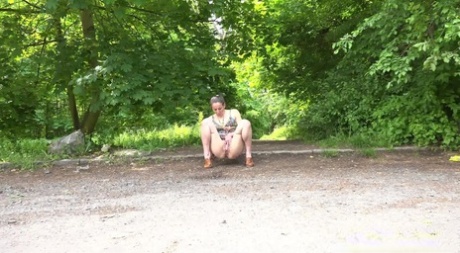 Caucasian chick Valentina Ross squats to pee in a parking lot near the woods