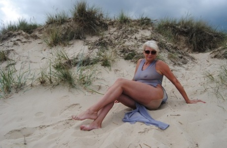 Older blonde amateur Dimonty models at the beach in see thru attire and shades