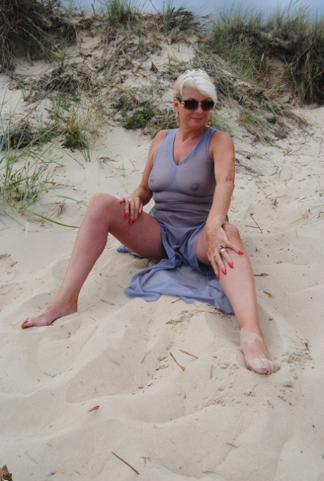 Older blonde amateur Dimonty models at the beach in see thru attire and shades