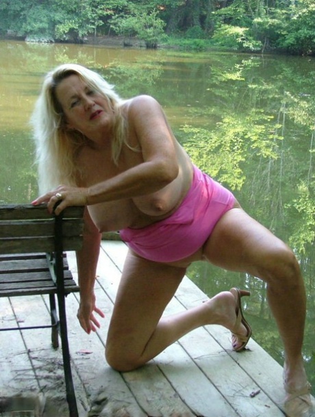 Older blonde Adonna makes her nude debut on a waterside deck