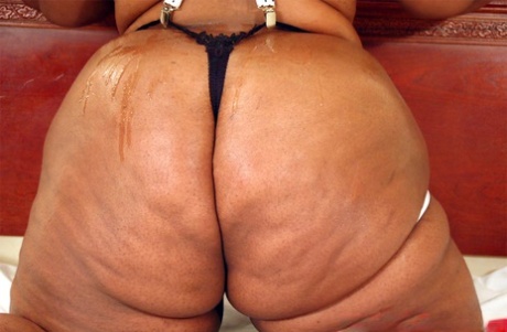 Ebony fatty Brenda Brickhouse puts a shine on her huge ass atop a bed