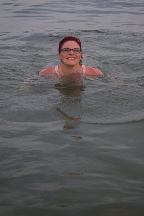 Tattooed redhead poses nude on a beach before masturbating on a toilet seat
